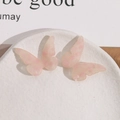 Detailopname van roze vlinderhangers van acetaat op een witte keramische schaal - Roze Vlinder