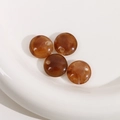 Dettaglio di perline tonde piatte in resina ambrata da 15mm per creazione gioielli fai-da-te - 1 Pezzo / Marrone