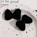 Close-up of a pair of plush black velvet bow hair clips on a decorative white tray - No Accessories / Black