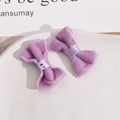 Close-up of two purple velvet handmade bow hairpins on a white textured ceramic tray - Light Purple