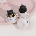 Detail of cute Shiba Inu resin figurine inside a white teacup with a golden hook - Black