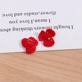 Detail von roten gehäkelten Blütenanhängern mit goldenem Metallring für DIY-Schmuck - Rot