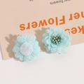 Detail van lichtblauwe gaasbloemen met groene meeldraad en vilt achterkant voor DIY sieraden - Lichtgroen