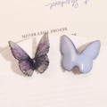 Dettaglio di ciondoli a farfalla in resina con glitter e sfumatura viola per gioielli fai da te - Viola
