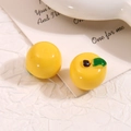 Macro di due ciondoli a forma di frutta in resina gialla in miniatura con foglie su bianco - Giallo