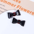 Detail view of handmade black acetate bow hair clips with gold France Handmade lettering - Black Purple