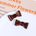 Detailed shot of two tortoiseshell acetate bow hair clips with France handmade lettering - Brown