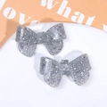 Close-up of two sparkling silver glitter resin bow accessories for DIY hair clips - Silver