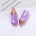 Macro view of purple marble resin pencil charms with golden metallic tips in a ceramic tray - Purple