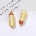 Macro shot of pencil-shaped resin charms with pearlescent yellow texture and brown tips - Yellow
