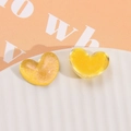 Close-up of heart-shaped glitter and translucent yellow resin DIY craft accessories - Yellow