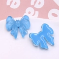 Close-up of two blue translucent resin bow charms for DIY jewelry and hair accessories - Sapphire Blue