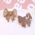 Macro detail of champagne wire-texture and coffee resin bow pendants for DIY jewelry - Light Coffee