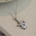 Gros plan d'un collier étoile de mer argenté avec strass brillants sur tissu texturé - Étoile de Mer Argentée Triple Blanche (EXRGN0411YS)