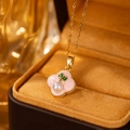 Nahaufnahme der goldenen Kirschblüten-Halskette mit rosa Blüten in einer Samtbox - Rosa Kleeblatt-Perlenkette