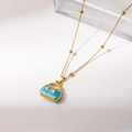 Detailed close-up of a gold necklace with light blue handbag pendant and floral enamel - Blue Style (0536)
