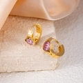 Detail of pink oval zircon huggie earrings in gold plated finish on white stone surface - Pink Eye Style (1410)