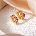 Close-up of golden hoop earrings with oval pink zircon stones on a white stone base - Pink Oval Eye Style (1417)