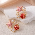 Vue détaillée des boucles d'oreilles étoile de mer et coquillage avec perles dorées - Boucles d'Oreilles Créoles Étoile de Mer Rouge (1500)