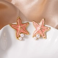 Vue macro de boucles d'oreilles étoile de mer rose avec perles et bordure dorée - Boucles d'Oreilles Clous Étoile de Mer Orange Perle (1514)