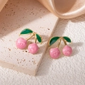 Vista macro di orecchini a fragola rosa con montatura dorata su seta color champagne - Stile Ciliegia Rosa con Foglia Verde (1534)