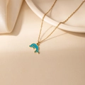 Collier avec pendentif dauphin en émail bleu et chaîne dorée dans un décor élégant - Dauphin Bleu Foncé