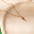 Macro detail of Christmas candy cane pendant with red enamel on gold steel chain - Christmas Cane Pendant Necklace