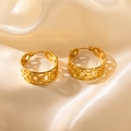 Elegant gold hollowed out geometric wing hoop earrings displayed on silk fabric - Circular Hollow Shape (0470)