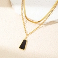 Detail of layered gold snake and paperclip chains with a black geometric pendant - Trapezoid Black Shell Necklace