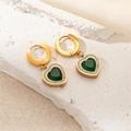 Close-up of heart-shaped gold earrings with emerald green gems and white zircons - Heart Emerald Earrings
