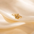 Macro shot of gold crown ring with zircons and twisted band on beige silk fabric - Crown Zircon Style (1663)