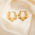 Macro shot of gold heart-shaped hoop earrings on elegant beige silk fabric background - Multiple Heart Earrings 0275