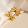 Détail de boucles d'oreilles nœud doré avec étoile sur tissu en soie champagne - Or Nœud Étoile (1755)