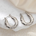 Minimalist silver wavy stainless steel hoop earrings on a textured stone surface - Lava Textured Earrings 0188