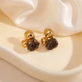 Gros plan détaillé de boucles d'oreilles géométriques en or et résine ambrée sur soie élégante - Nœud Pierre Noire Clou (1808)