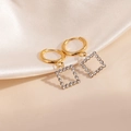 Boucles d'oreilles créoles carrées en or et zircon sur un tissu en soie de couleur crème - Boucles d'Oreilles Zirconia Blanc Carré Creux