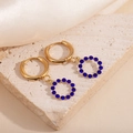 Detail goldener Creolen mit rundem Anhänger und blauen Zirkonia-Steinen besetzt - Hohlreifen Blaue Zirkonia Ohrringe