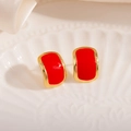Détail des boucles d'oreilles courbées en émail rouge et or sur plateau coquille - Pierre Rouge Géométrique Clou (1852)
