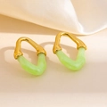 Gros plan détaillé de boucles d'oreilles géométriques en or et résine verte sur soie - Bordure Dorée Style Double V (1890)