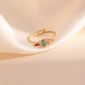 Détail macro d'une bague dorée réglable avec des zircons colorés en forme de trèfle - Style Conique Multicolore