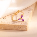 Détail d'une bague ouverte dorée torsadée avec trois pierres marquises violettes - Style Trèfle Violet