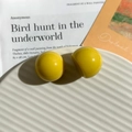 Dettaglio degli orecchini a lobo in resina gialla su vassoio decorativo bianco - Stile Tondo Giallo