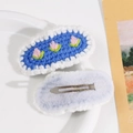 Close-up of hand-crocheted oval hair clip with tulip embroidery and metal BB clip - Light Blue
