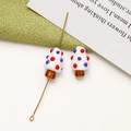 Primer plano de cuentas de vidrio con forma de hongo y motas de colores para joyería DIY - Blanco