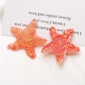 Détail de breloques étoiles de mer en résine dégradée avec paillettes pour accessoires DIY - Orange