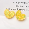 Makro-Detail von gelben Harzherzen mit Glitzer-Pailletten für DIY-Schmuck - Hellgelb