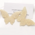 Detailed view of beige butterfly resin charms with sparkling fine glitter texture - Beige