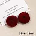 Macro shot of deep red flocked earrings with twisted rings and triangle cut-outs - Small Spiral (21# Small Spiral, 1pc)