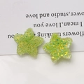 Macro shot of 20mm green resin stars with sugar sequins and glitter for DIY jewelry making - Green