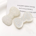 Vista macro di fiocchi in resina con paillettes iridescenti per gioielli fai-da-te e capelli - Bianco